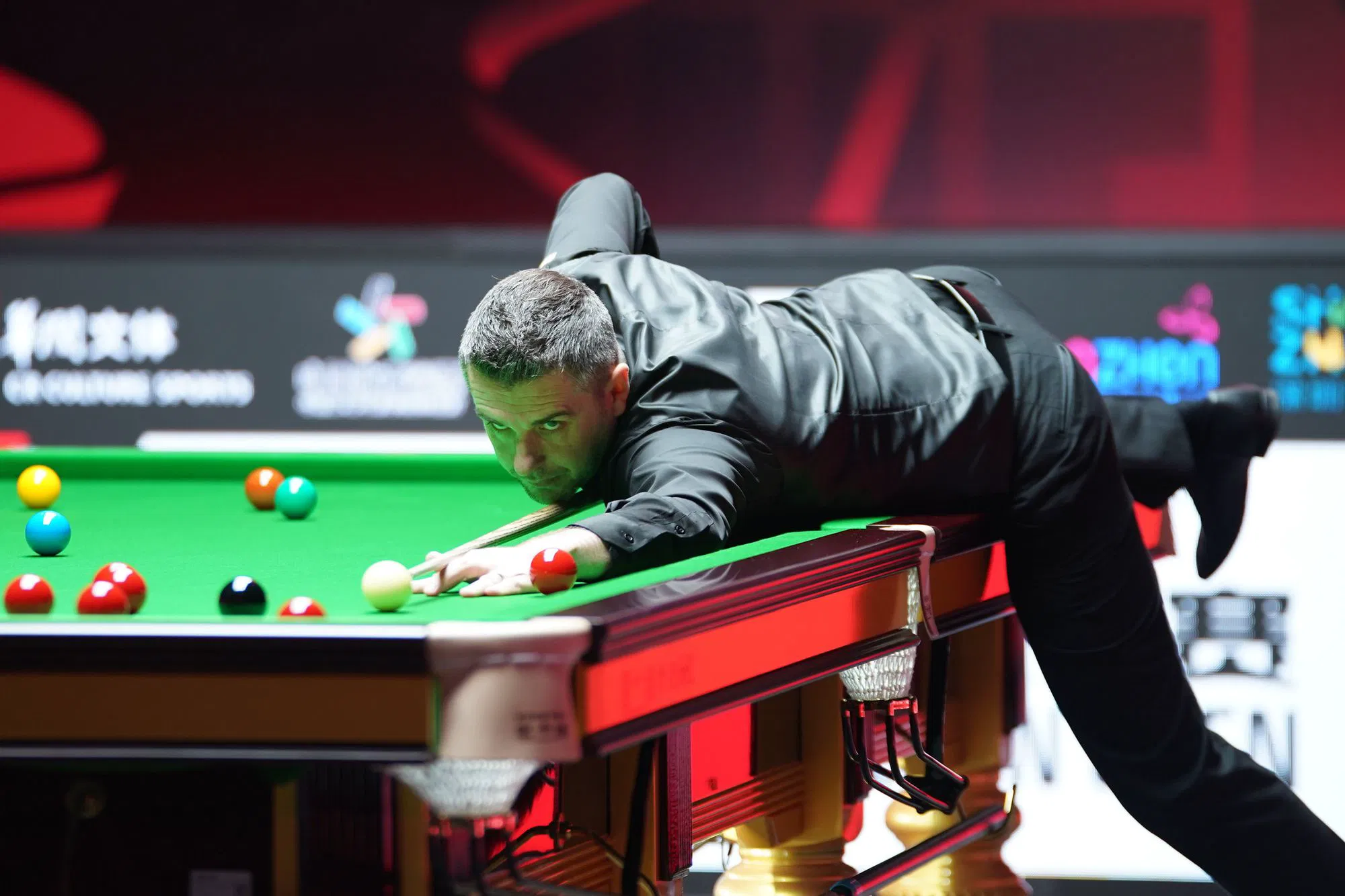 Mark Selby at the table against Judd Trump in Shenzhen